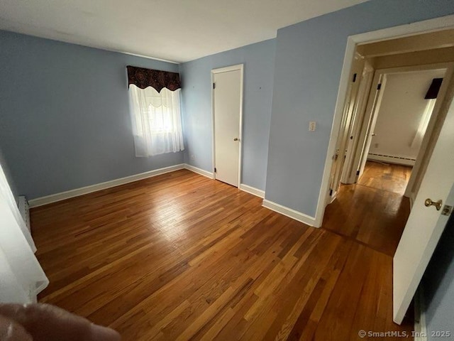 117 Lyons Rd, Bristol, CT 06010 - unfurnished bedroom featuring wood finished floors and a baseboard radiator