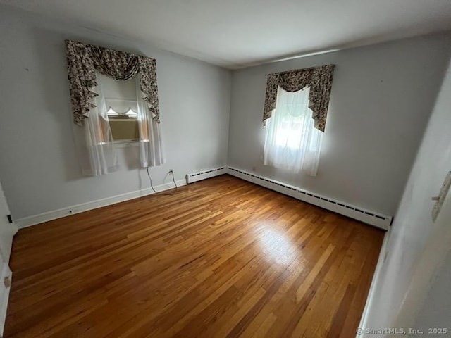 117 Lyons Rd, Bristol, CT 06010 - empty room with wood finished floors and a baseboard heating unit