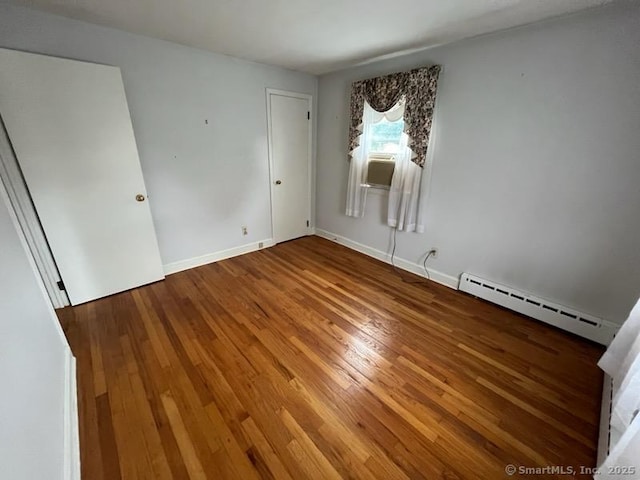 117 Lyons Rd, Bristol, CT 06010 - unfurnished bedroom with a baseboard heating unit and wood finished floors