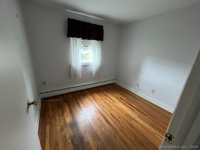 117 Lyons Rd, Bristol, CT 06010 - spare room with wood finished floors and a baseboard heating unit