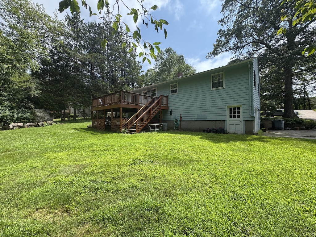 105 Chesterfield Rd, East Lyme, CT 06333 - rear view of property with stairway, a deck, and a lawn