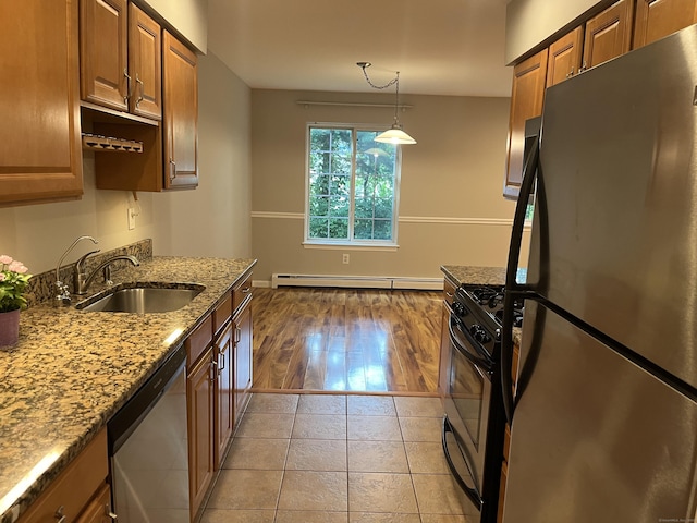 2955 Madison Ave Apt 40, Bridgeport, CT 06606 - kitchen featuring appliances with stainless steel finishes, baseboard heating, light stone countertops, brown cabinets, and hanging light fixtures