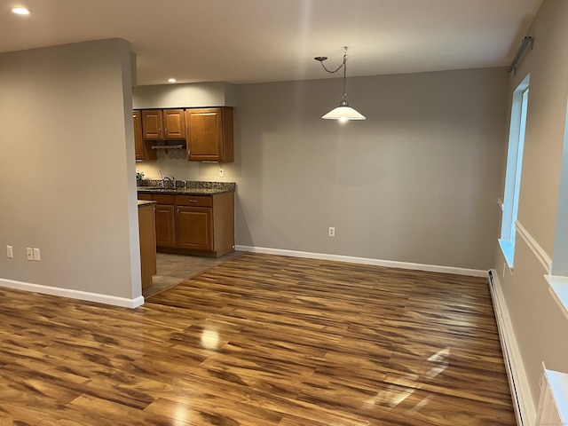 2955 Madison Ave Apt 40, Bridgeport, CT 06606 - kitchen with recessed lighting, a baseboard heating unit, wood finished floors, dark countertops, and hanging light fixtures