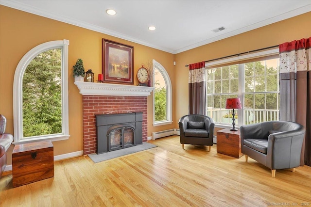 2 Kimberly Way, Marlborough, CT 06447 - living area with a baseboard radiator, wood finished floors, healthy amount of natural light, ornamental molding, and a brick fireplace
