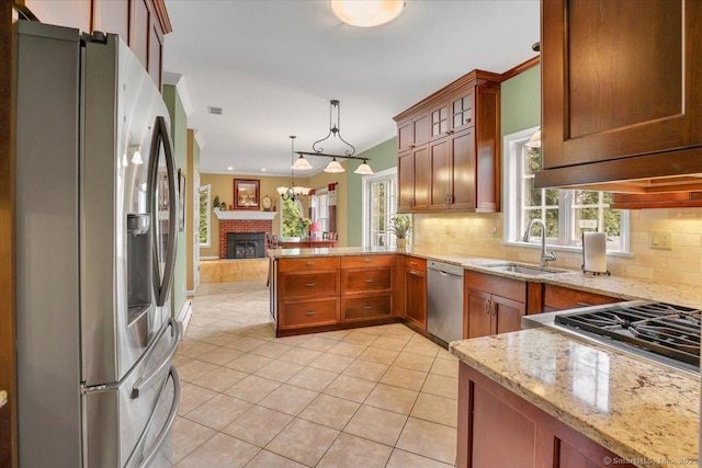 2 Kimberly Way, Marlborough, CT 06447 - kitchen with stainless steel appliances, light tile patterned floors, tasteful backsplash, a brick fireplace, and a peninsula