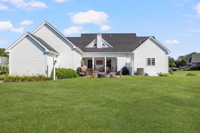 14 Finn Ln, Plainfield, CT 06374 - back of property featuring a yard, a patio area, roof with shingles, and a chimney