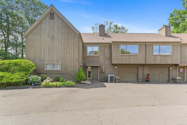 194 Bayfield Ln Unit A, Stratford, CT 06614 - view of front facade featuring a chimney, roof with shingles, an attached garage, and asphalt driveway