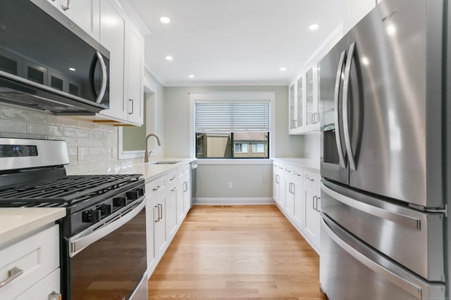 194 Bayfield Ln Unit A, Stratford, CT 06614 - kitchen featuring stainless steel appliances, light countertops, decorative backsplash, light wood-type flooring, and white cabinetry