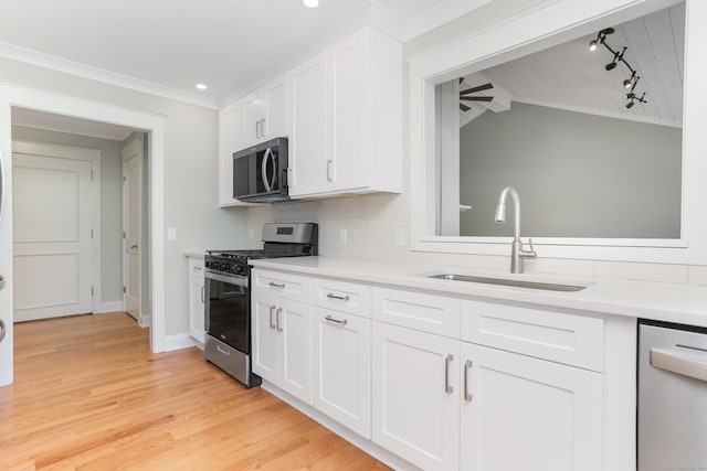 194 Bayfield Ln Unit A, Stratford, CT 06614 - kitchen featuring stainless steel appliances, white cabinets, light wood-style flooring, light countertops, and ornamental molding