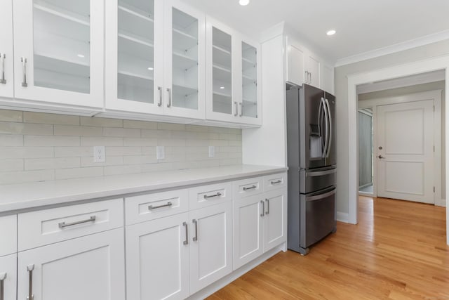 194 Bayfield Ln Unit A, Stratford, CT 06614 - kitchen with stainless steel fridge, white cabinetry, light countertops, glass insert cabinets, and tasteful backsplash