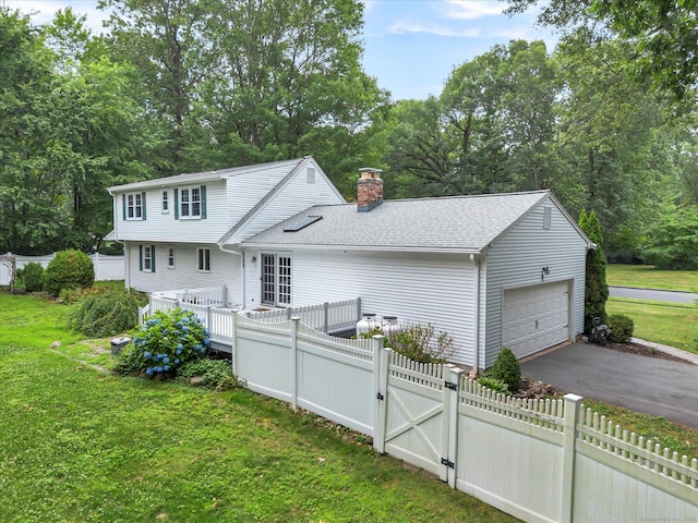 7 Lorraine Rd, Manchester, CT 06040 - back of house with a garage, a chimney, a gate, a shingled roof, and view of wooded area
