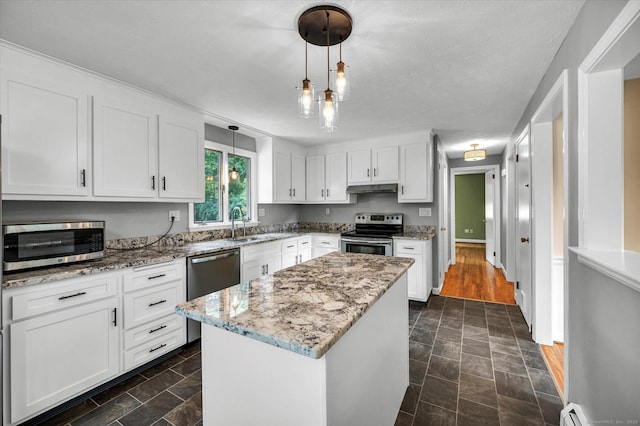7 Lorraine Rd, Manchester, CT 06040 - kitchen featuring appliances with stainless steel finishes, white cabinetry, under cabinet range hood, light stone countertops, and decorative light fixtures