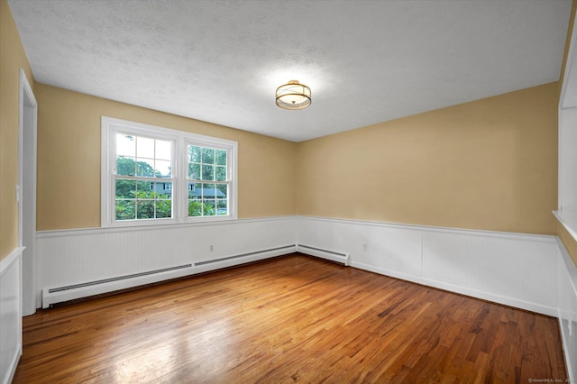 7 Lorraine Rd, Manchester, CT 06040 - unfurnished room featuring baseboard heating, a wainscoted wall, wood finished floors, and a textured ceiling
