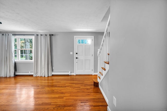7 Lorraine Rd, Manchester, CT 06040 - foyer featuring a textured ceiling, healthy amount of natural light, stairs, wood finished floors, and a baseboard heating unit