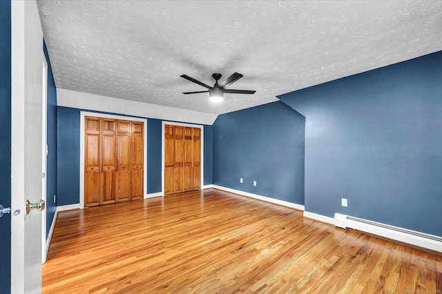7 Lorraine Rd, Manchester, CT 06040 - unfurnished bedroom featuring a baseboard radiator, wood finished floors, multiple closets, a textured ceiling, and ceiling fan