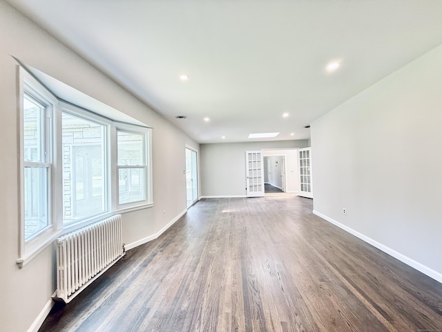 10 Meadowpark Ave W, Stamford, CT 06905 - unfurnished living room with radiator heating unit, wood finished floors, recessed lighting, and french doors