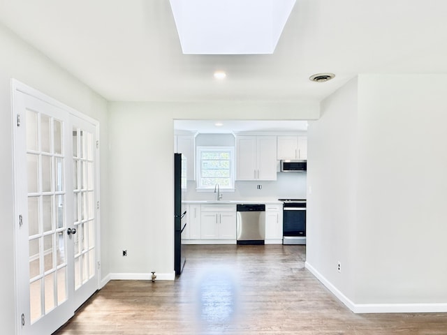 10 Meadowpark Ave W, Stamford, CT 06905 - kitchen with appliances with stainless steel finishes, wood finished floors, white cabinetry, light countertops, and recessed lighting