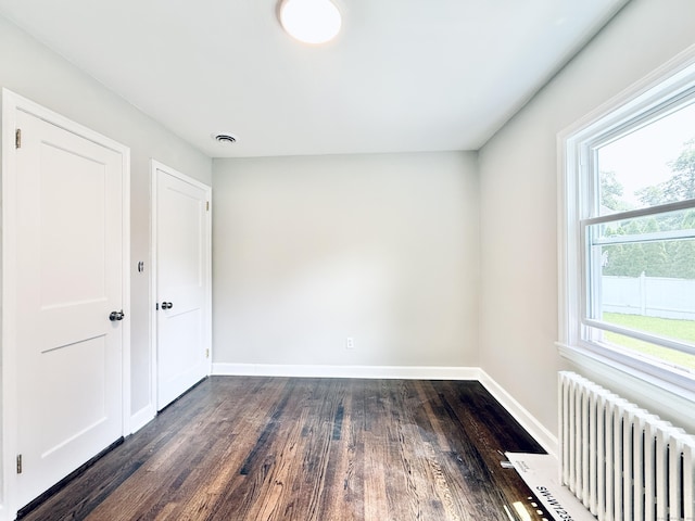 10 Meadowpark Ave W, Stamford, CT 06905 - spare room featuring radiator heating unit, dark wood-style floors, and plenty of natural light