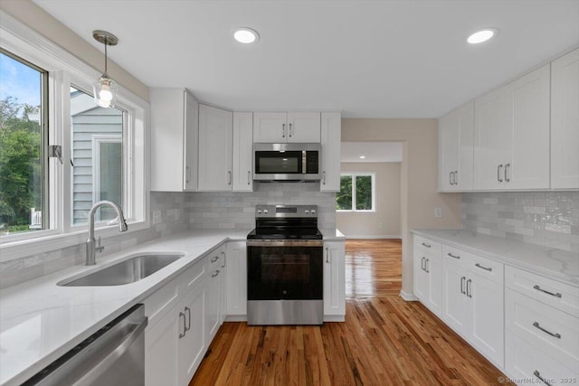 219 Browning Rd, Norwich, CT 06360 - kitchen featuring stainless steel appliances, white cabinetry, tasteful backsplash, light stone counters, and recessed lighting