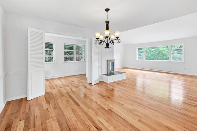 195 Whittier Rd, New Haven, CT 06515 - unfurnished living room featuring a baseboard radiator, light wood finished floors, a chandelier, and a brick fireplace