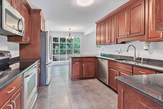 195 Whittier Rd, New Haven, CT 06515 - kitchen featuring appliances with stainless steel finishes, a chandelier, a peninsula, light tile patterned flooring, and dark stone countertops