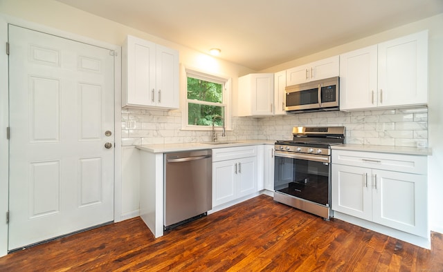 112 Pitt St, Bridgeport, CT 06606 - kitchen with appliances with stainless steel finishes, light countertops, decorative backsplash, dark wood-type flooring, and white cabinets