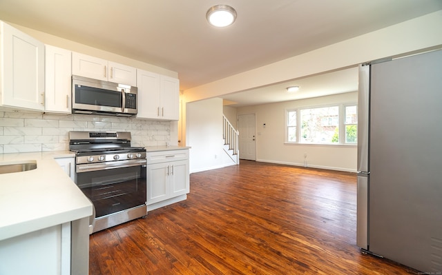 112 Pitt St, Bridgeport, CT 06606 - kitchen with appliances with stainless steel finishes, dark wood-type flooring, light countertops, backsplash, and white cabinets