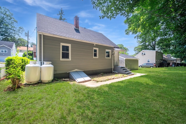 112 Pitt St, Bridgeport, CT 06606 - rear view of property featuring a chimney, roof with shingles, and a yard