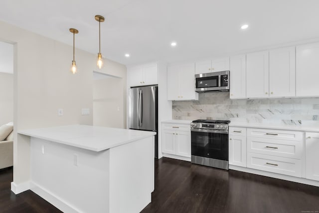 39 Cambridge Dr, Greenwich, CT 06831 - kitchen with stainless steel appliances, dark wood-style flooring, tasteful backsplash, white cabinetry, and a peninsula