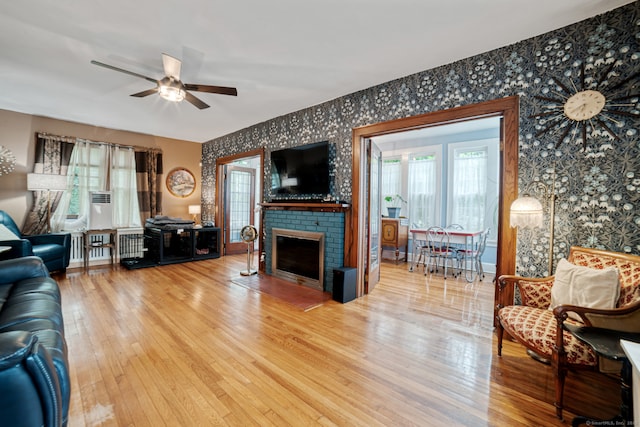 135 Park Ter, Waterbury, CT 06708 - living area featuring wallpapered walls, hardwood / wood-style floors, ceiling fan, a brick fireplace, and radiator