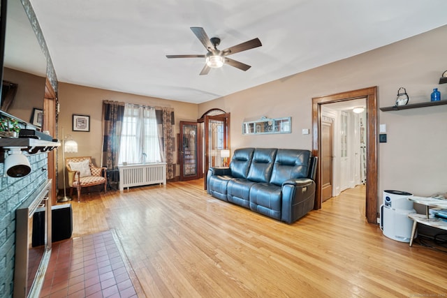 135 Park Ter, Waterbury, CT 06708 - living area with radiator heating unit, light wood-style flooring, ceiling fan, and a fireplace