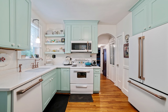135 Park Ter, Waterbury, CT 06708 - kitchen with white appliances, green cabinets, arched walkways, backsplash, and light wood finished floors