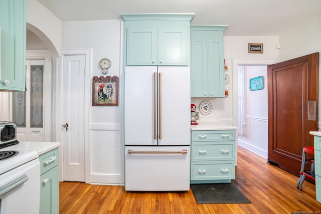 135 Park Ter, Waterbury, CT 06708 - kitchen featuring high end white refrigerator, wood finished floors, arched walkways, green cabinets, and light countertops