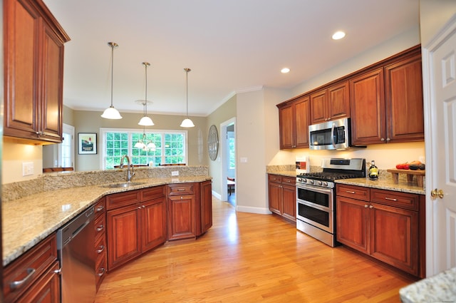 190 Shadow Pond, Suffield, CT 06078 - kitchen featuring appliances with stainless steel finishes, light wood-style floors, a peninsula, hanging light fixtures, and crown molding