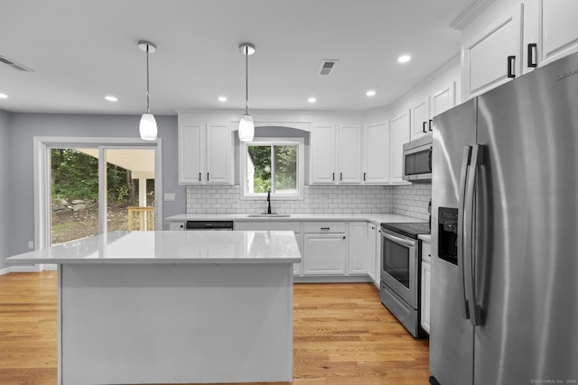 302 Fieldwood Rd, Waterbury, CT 06704 - kitchen featuring appliances with stainless steel finishes, light countertops, white cabinets, light wood-style flooring, and tasteful backsplash