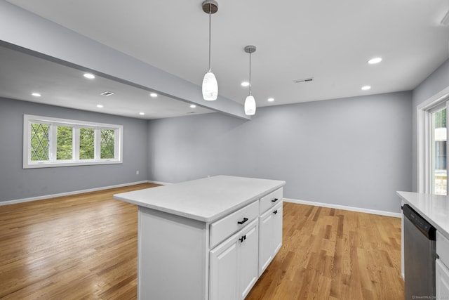 302 Fieldwood Rd, Waterbury, CT 06704 - kitchen with dishwasher, light countertops, white cabinets, hanging light fixtures, and light wood-type flooring