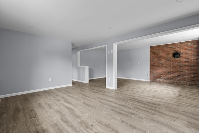 302 Fieldwood Rd, Waterbury, CT 06704 - unfurnished living room featuring wood finished floors and brick wall