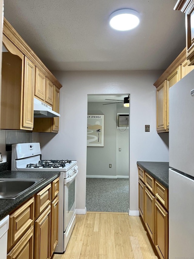 280 Gardner Ave Unit D4, New London, CT 06320 - kitchen with white appliances, under cabinet range hood, dark countertops, and light wood finished floors