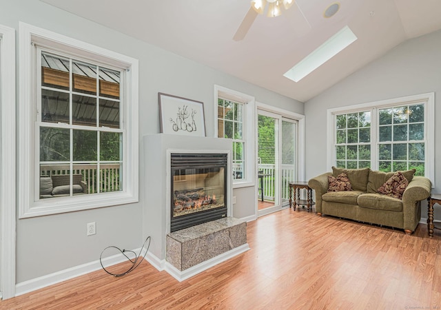 93 Cook Hill Rd, Killingly, CT 06239 - living area with a ceiling fan, a glass covered fireplace, light wood-style floors, a skylight, and vaulted ceiling