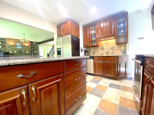 29 Grumman Ave, Wilton, CT 06897 - kitchen featuring stainless steel appliances, decorative backsplash, glass insert cabinets, brown cabinets, and light stone countertops