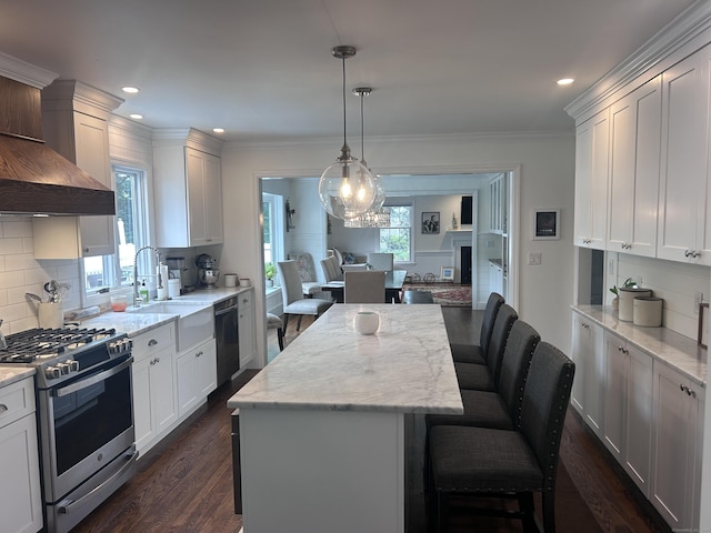 8 Sharon Ln, Old Saybrook, CT 06475 - kitchen with appliances with stainless steel finishes, custom exhaust hood, dark wood-type flooring, a kitchen island, and backsplash