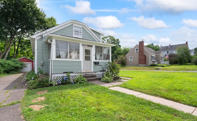20 Harris St, Enfield, CT 06082 - bungalow with an outdoor structure, a garage, a front yard, and a sunroom