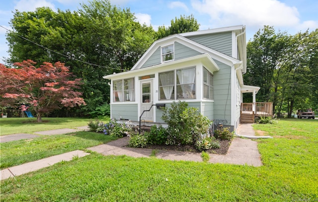 20 Harris St, Enfield, CT 06082 - view of front facade featuring a front lawn, a deck, and a sunroom