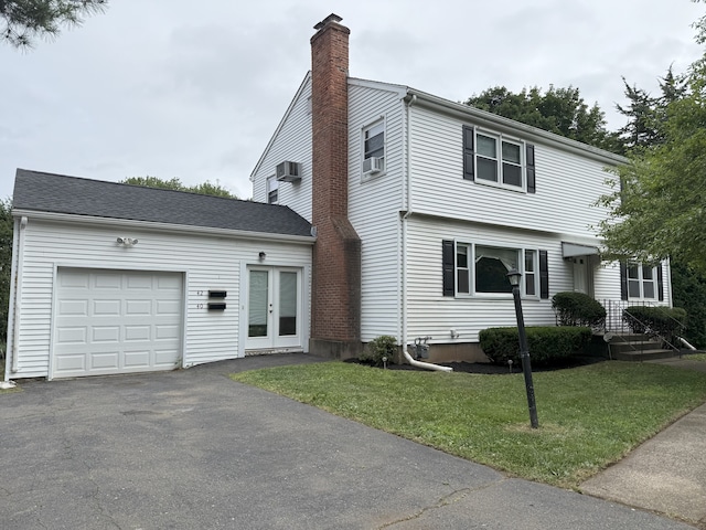40 Newton St, Berlin, CT 06037 - colonial inspired home with a chimney, an attached garage, a front yard, driveway, and french doors