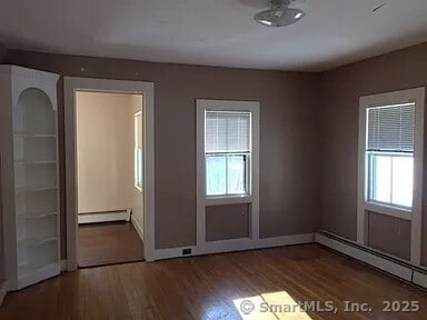 130 Westchester Rd, Colchester, CT 06415 - spare room with a baseboard radiator, wood finished floors, and plenty of natural light