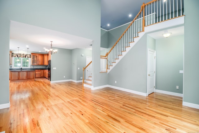 21 Great Heron Ln Unit 21, Brookfield, CT 06804 - unfurnished living room featuring light wood-style flooring, stairway, a chandelier, and recessed lighting