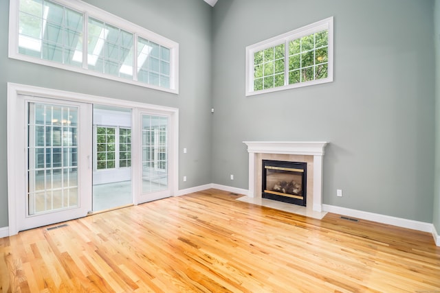 21 Great Heron Ln Unit 21, Brookfield, CT 06804 - unfurnished living room with wood finished floors, a fireplace, and a towering ceiling