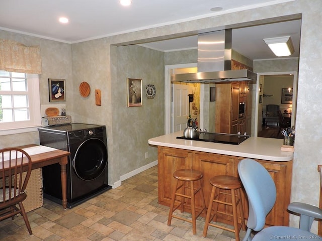 29 Graham Rd, East Windsor, CT 06016 - kitchen featuring wall chimney exhaust hood, washer / clothes dryer, black electric stovetop, light countertops, and brown cabinets