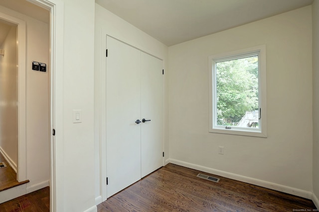 35 Millo Dr, Monroe, CT 06468 - unfurnished bedroom featuring multiple windows, dark wood-type flooring, and a closet