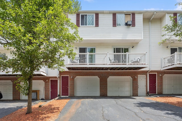 152 Lincoln St Unit 17, Waterbury, CT 06710 - view of front facade with a garage, asphalt driveway, and brick siding